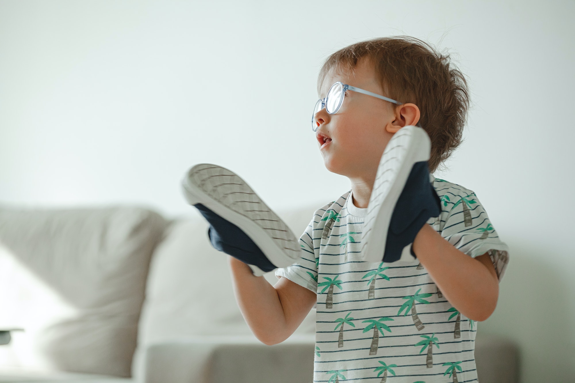 Child with autism in glasses play with his shoes