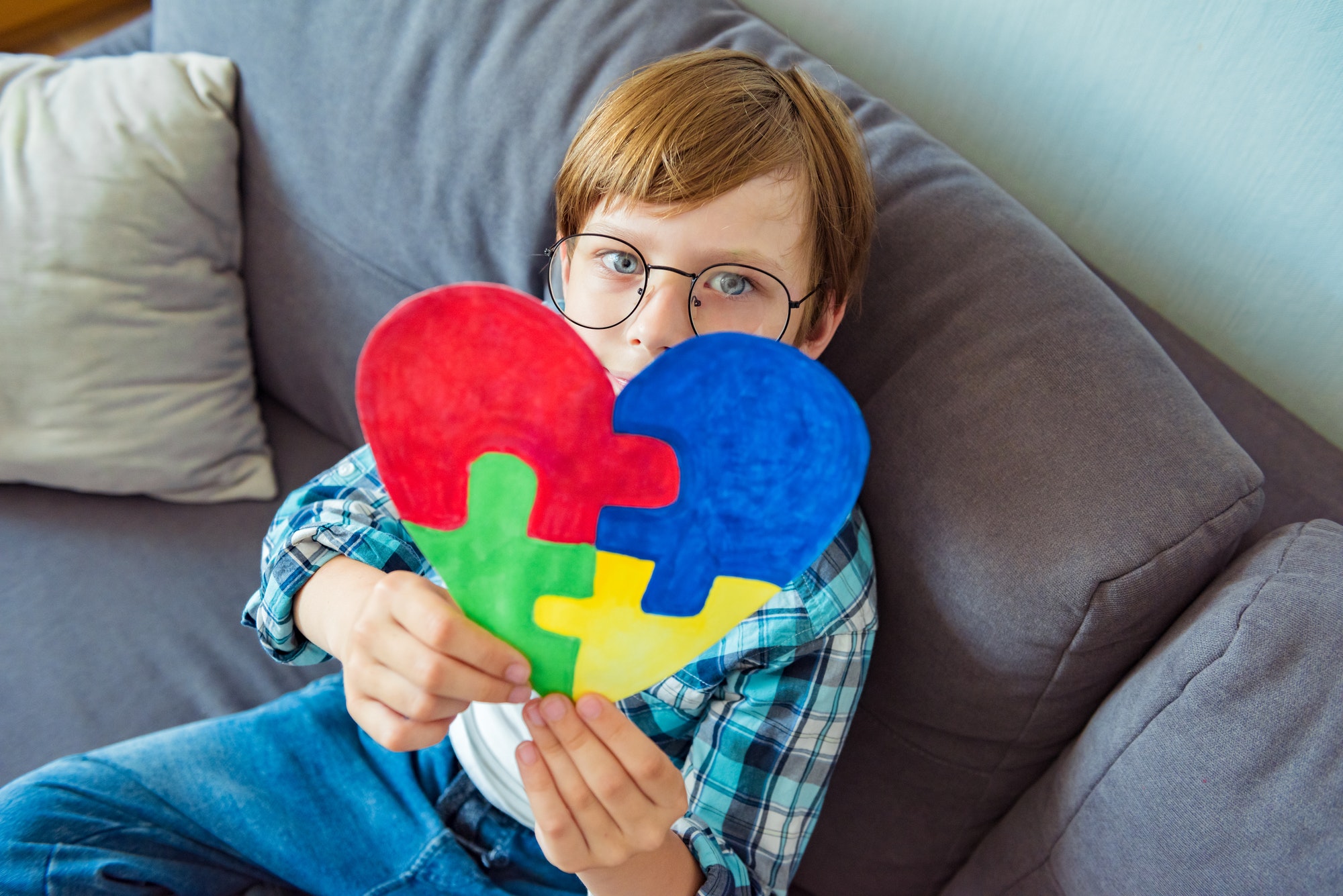 Young boy holding puzzle jigsaw, child mental health concept, world autism awareness day, autism